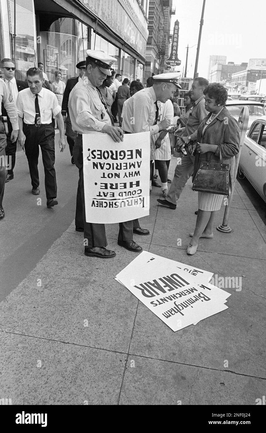 A police officer takes names of a small group of Black demonstrators