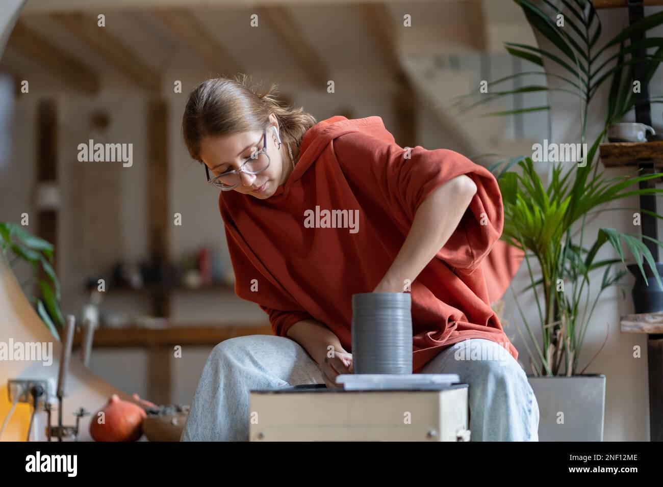 Pottery artist owner ceramic store woman making shaping clay product vase or jar in modern workshop. Stock Photo