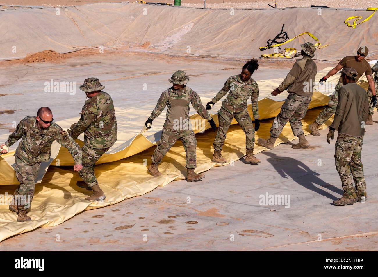 Prince Sultan Air Base, Saudi Arabia. 8th Feb, 2023. U.S. Air Force Airmen assigned to the 378th Expeditionary Logistics Readiness Squadron, help spread out a fuel bladder bag on Prince Sultan Air Base, Saudi Arabia, February. 8, 2023. The entire 378th ELRS came together to aid the Petroleum, Oil and Lubricant section in spreading two-ton bags across more than 5,600 square feet of difficult to navigate terrain, epitomizing how effective unit cohesion produces unrivaled expeditionary logistics with unequaled success. Credit: U.S. Air Force/ZUMA Press Wire Service/ZUMAPRESS.com/Alamy Live News Stock Photo