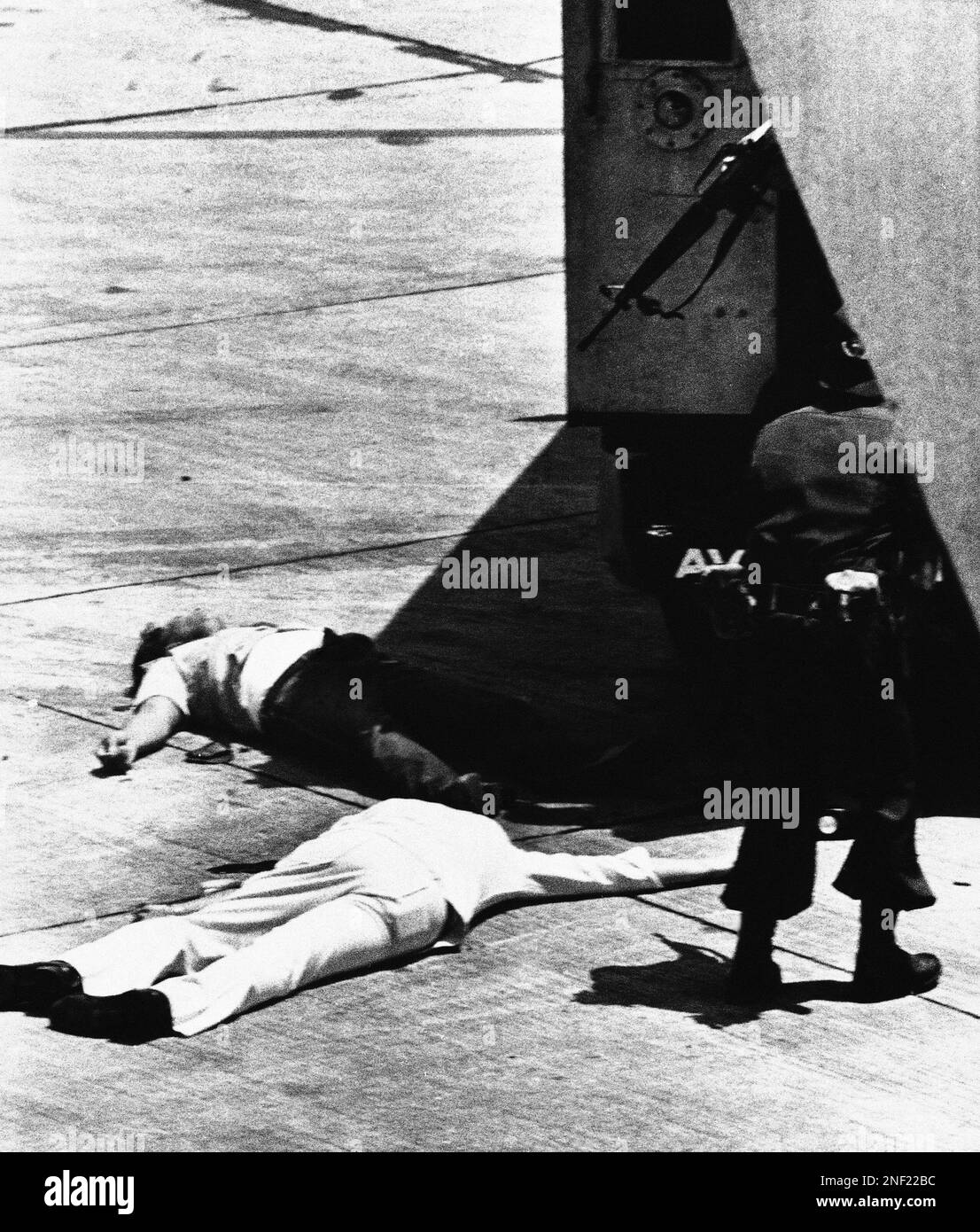 Filipino security guards, right, with M-16 rifles, watch two bodies ...