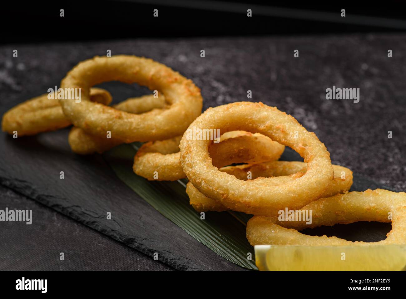 onion or calamari rings in breadcrumbs on a black board. High quality photo Stock Photo