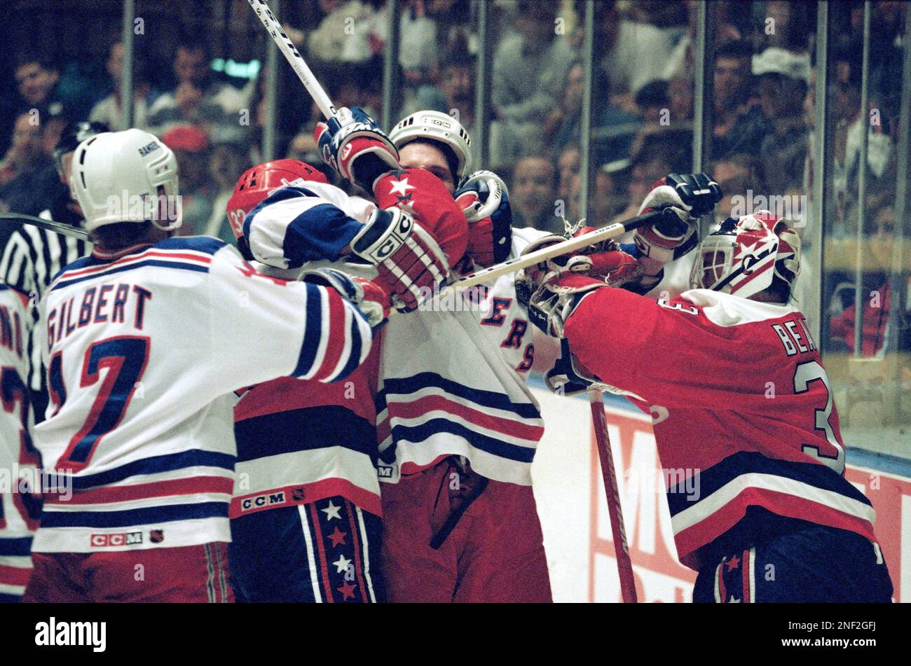 New York Rangers' Joe Kocur, center, gets roughed up by Washington