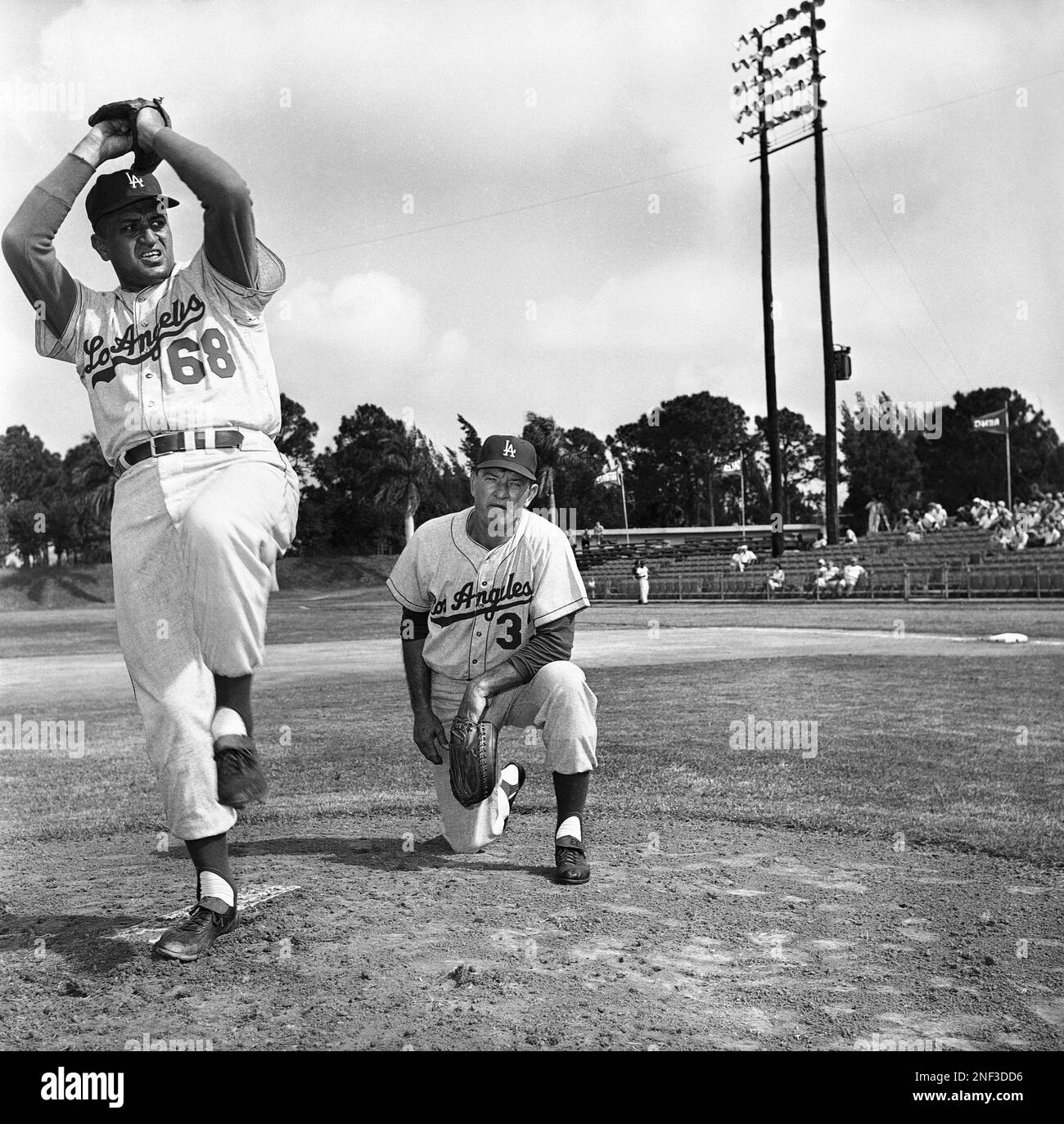 Don Newcombe, a former star pitcher for the Los Angeles Dodgers, warms up  under the watchful eye of coach Joe Becker as he gets ready to be the first  batting practice pitcher