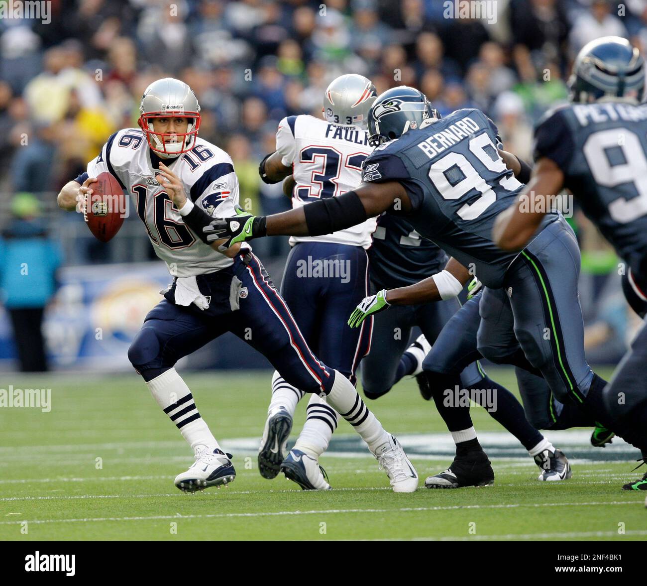 New England Patriots' quarterback Matt Cassel, left is pursued by Seattle  Seahawks defensive tackle Rocky Bernard (99) during an NFL football game  Sunday, Dec. 7, 2008, in Seattle. (AP Photo/Elaine Thompson Stock