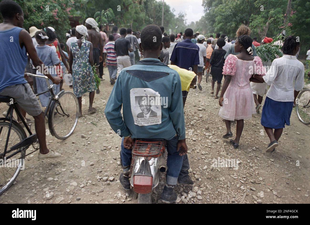 A young Haitian wears a portrait of President JeanBertrand Aristide on