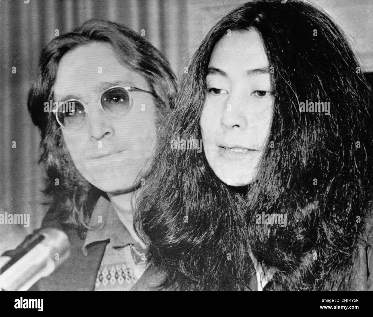 John Lennon and with his wife Yoko Ono shown April 2, 1973 in New York. They are answering questions at a news conference after a deportation hearing. (AP Photo/Jim Wells) Stock Photo