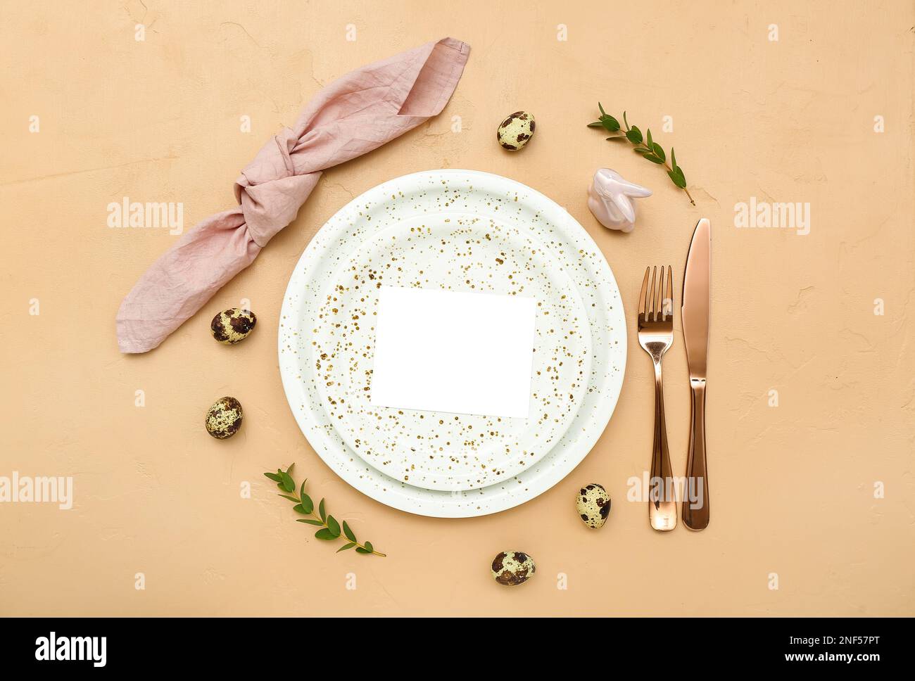 Stylish table setting with blank card and Easter eggs on color background Stock Photo