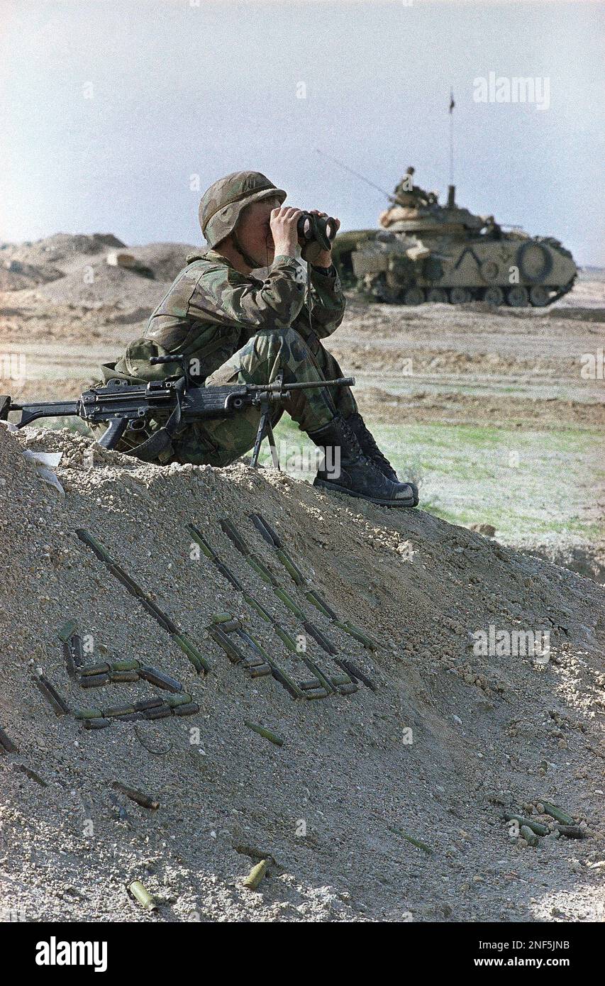 Pfc. Shawn Milam of West Virginia uses binoculars to observe the Iraqi