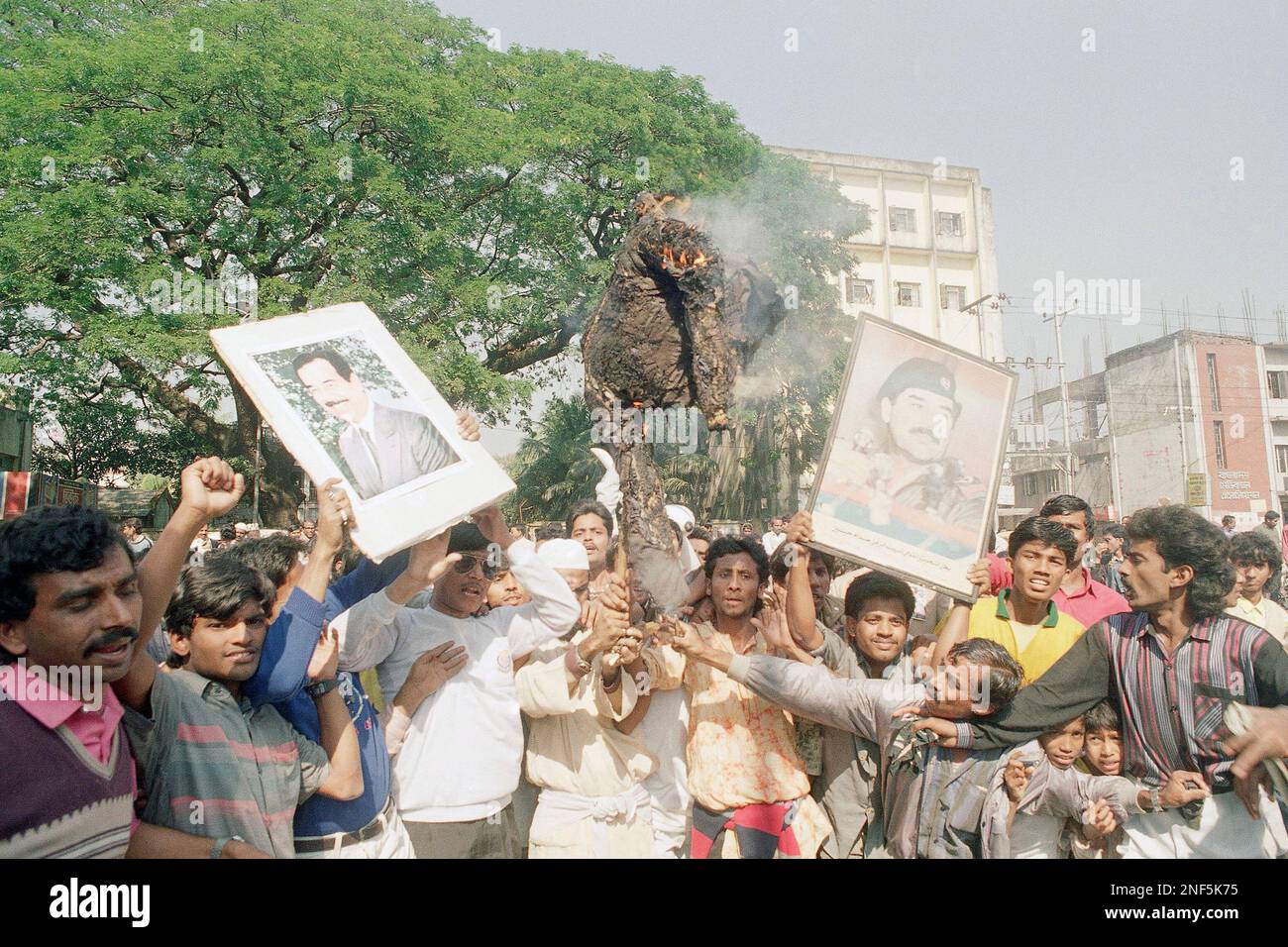 Demonstrators raise portraits of Iraqi President Saddam Hussein while ...
