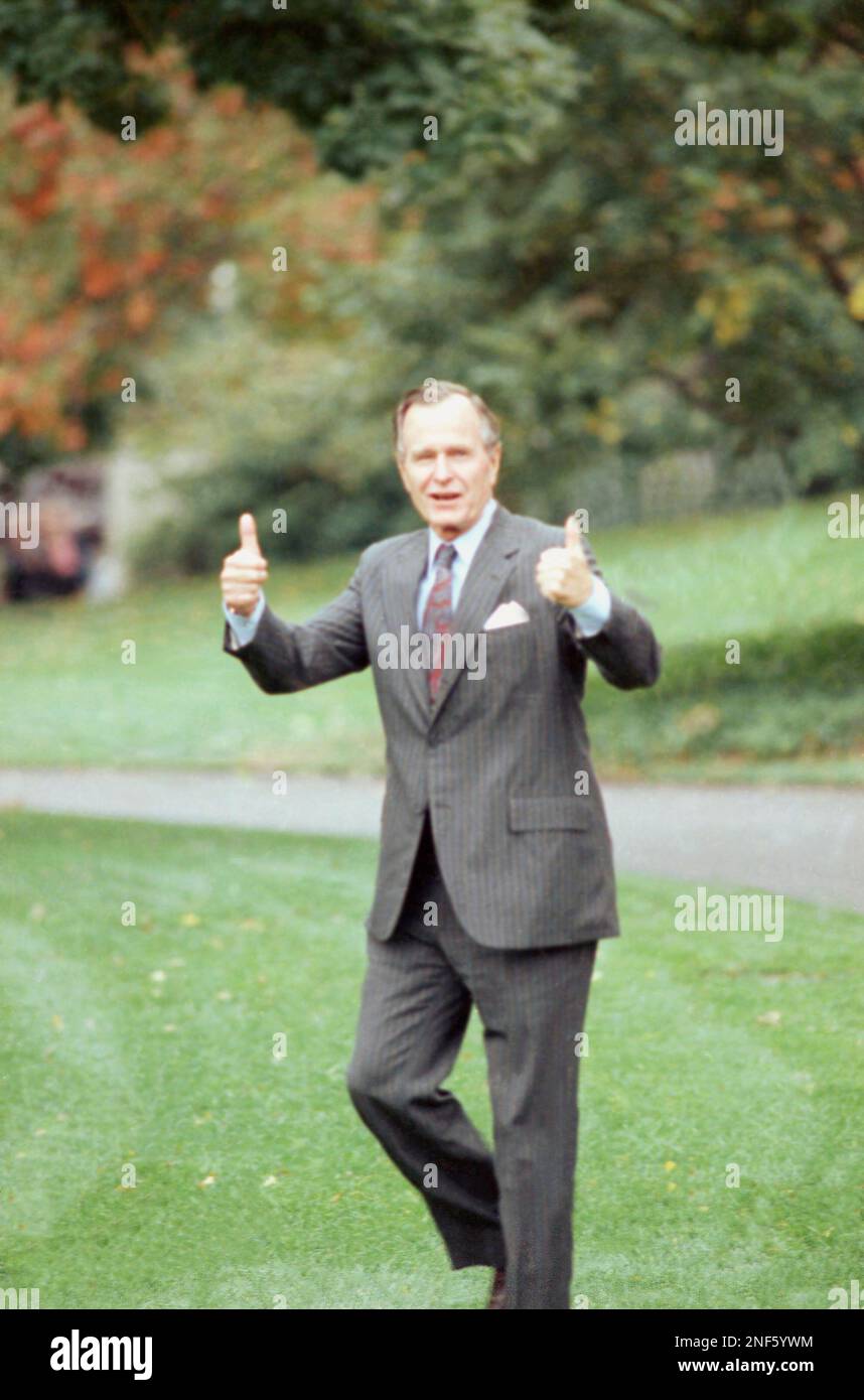 U.S. President George H. Bush gives a double thumbs-up when asked about ...