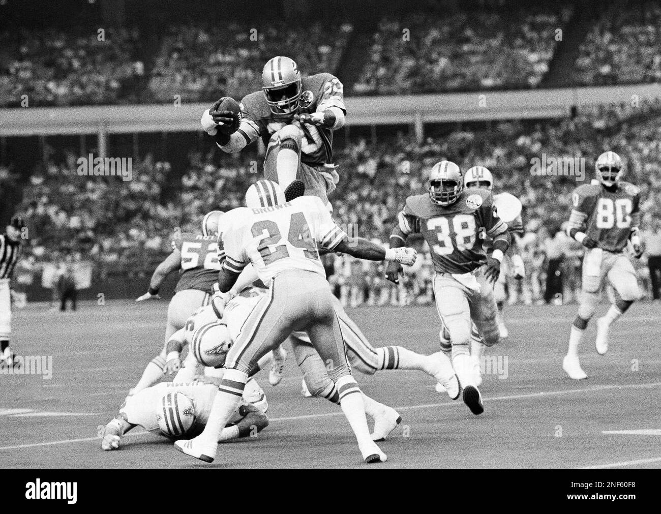 Detroit Lions halfback Billy Sims leaps over Houston Oilers Bob