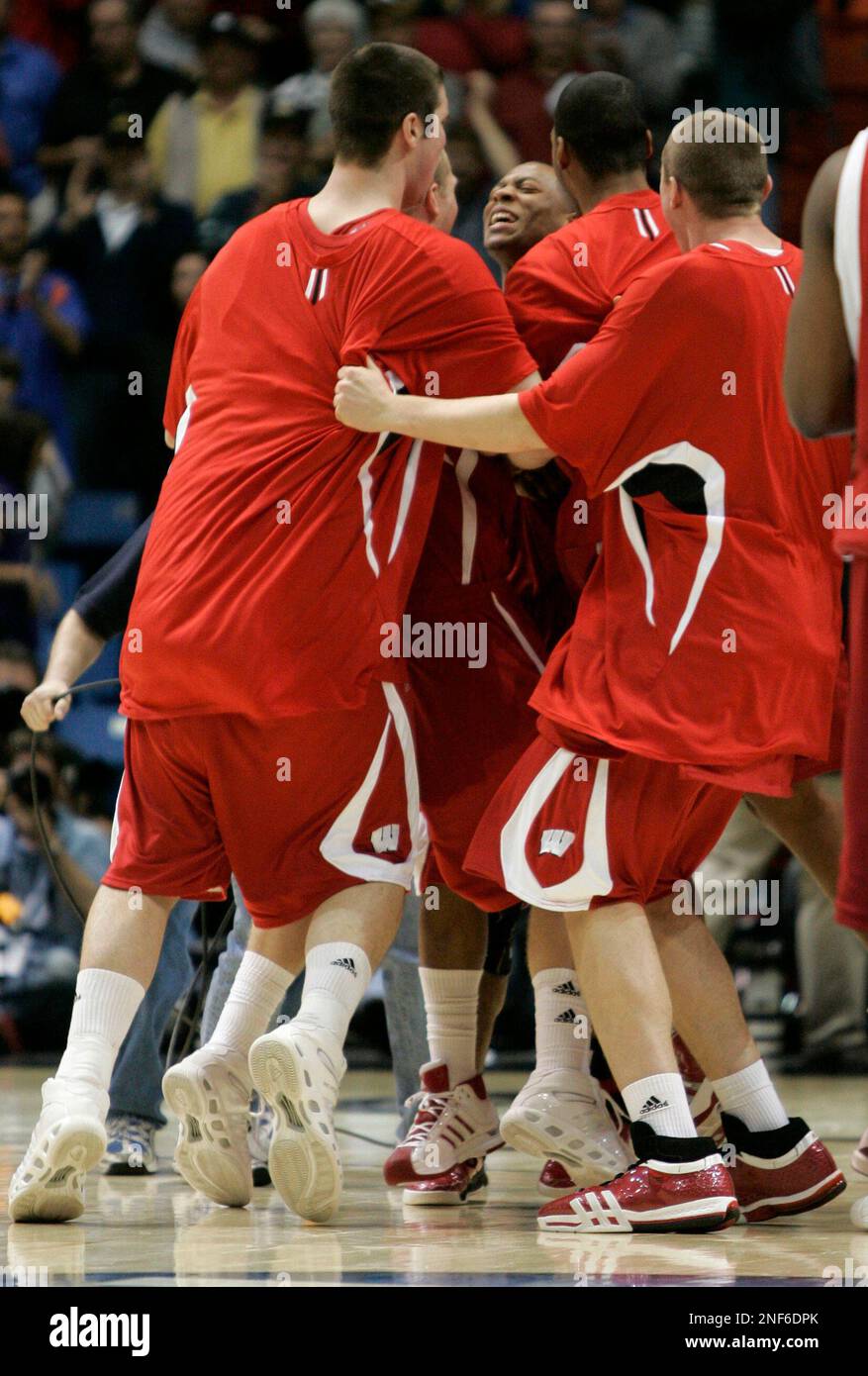 Wisconsin team surrounds guard Trevon Hughes after Wisconsin upset