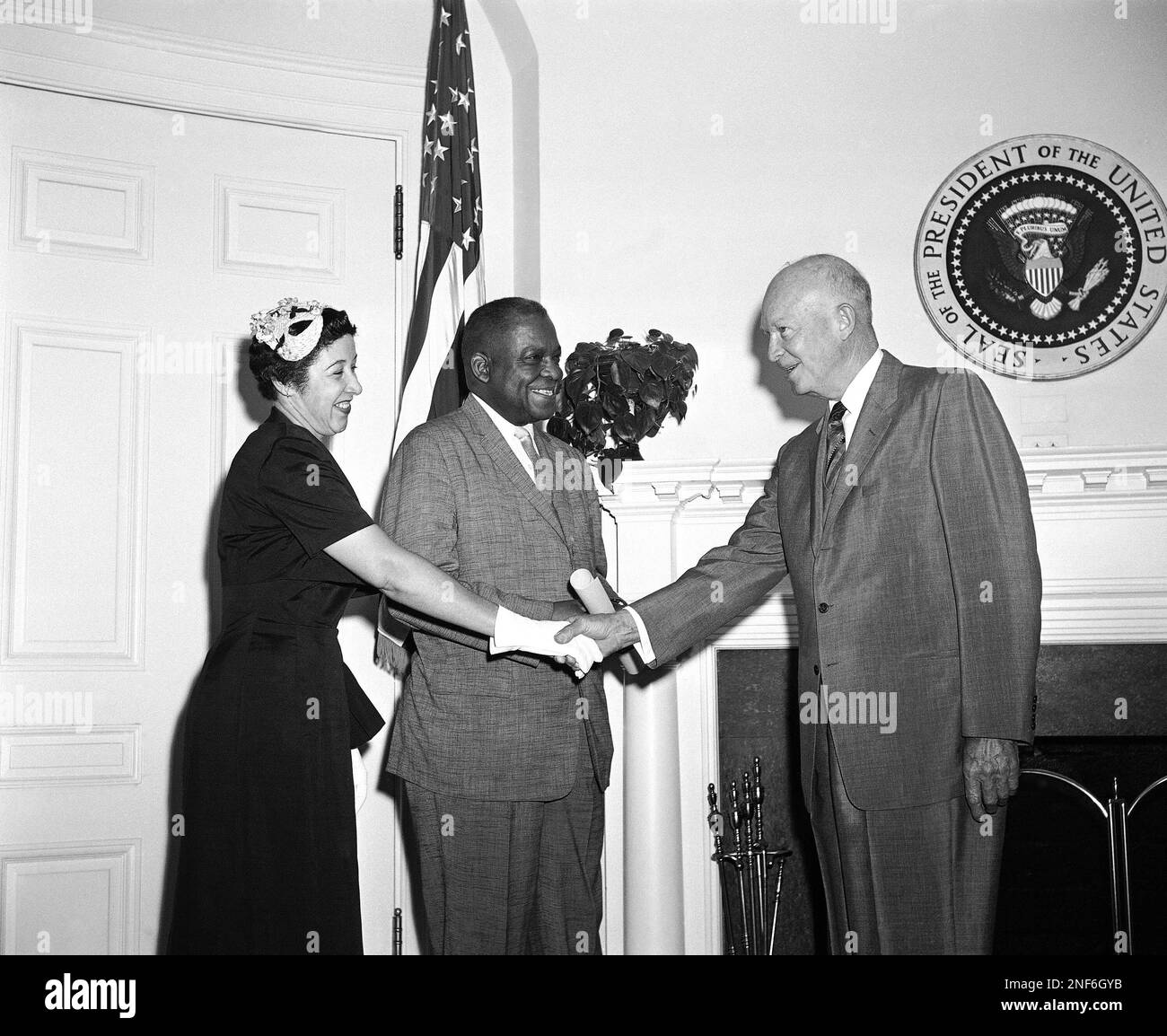 President Dwight D. Eisenhower reaches across George M. Johnson, new ...