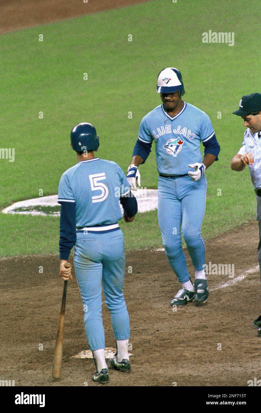 Toronto Blue Jays' George Bell comes home as Rance Mulliniks waits at the  plate after Bell hit his second homer against the New York Yankees in New  York, Monday, night, June 9