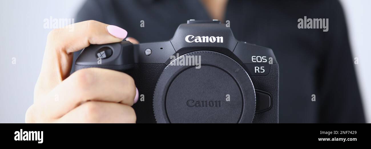 Tbilisi, Georgia - July 26, 2022: Person holding modern Canon EOS R5 camera closeup in hand Stock Photo