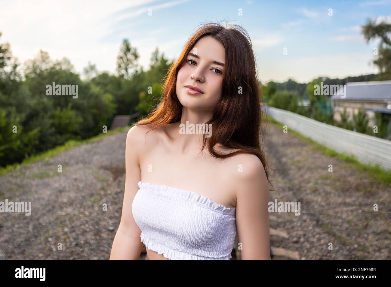 Outdoor close up portrait of young beautiful woman in top posing ...