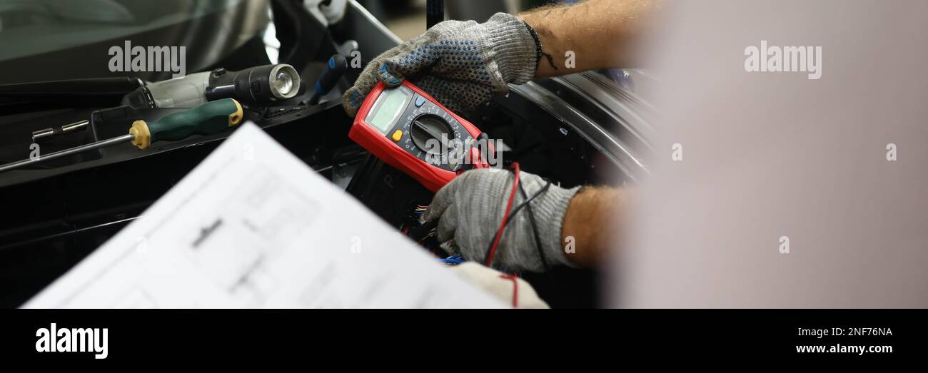Mechanical service using multimeter to check voltage level in car