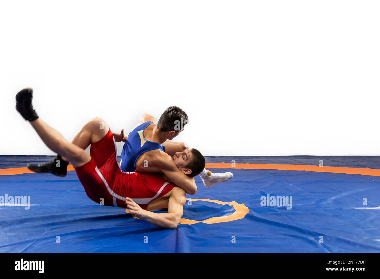 Two young men in blue and red wrestling tights are wrestlng and making