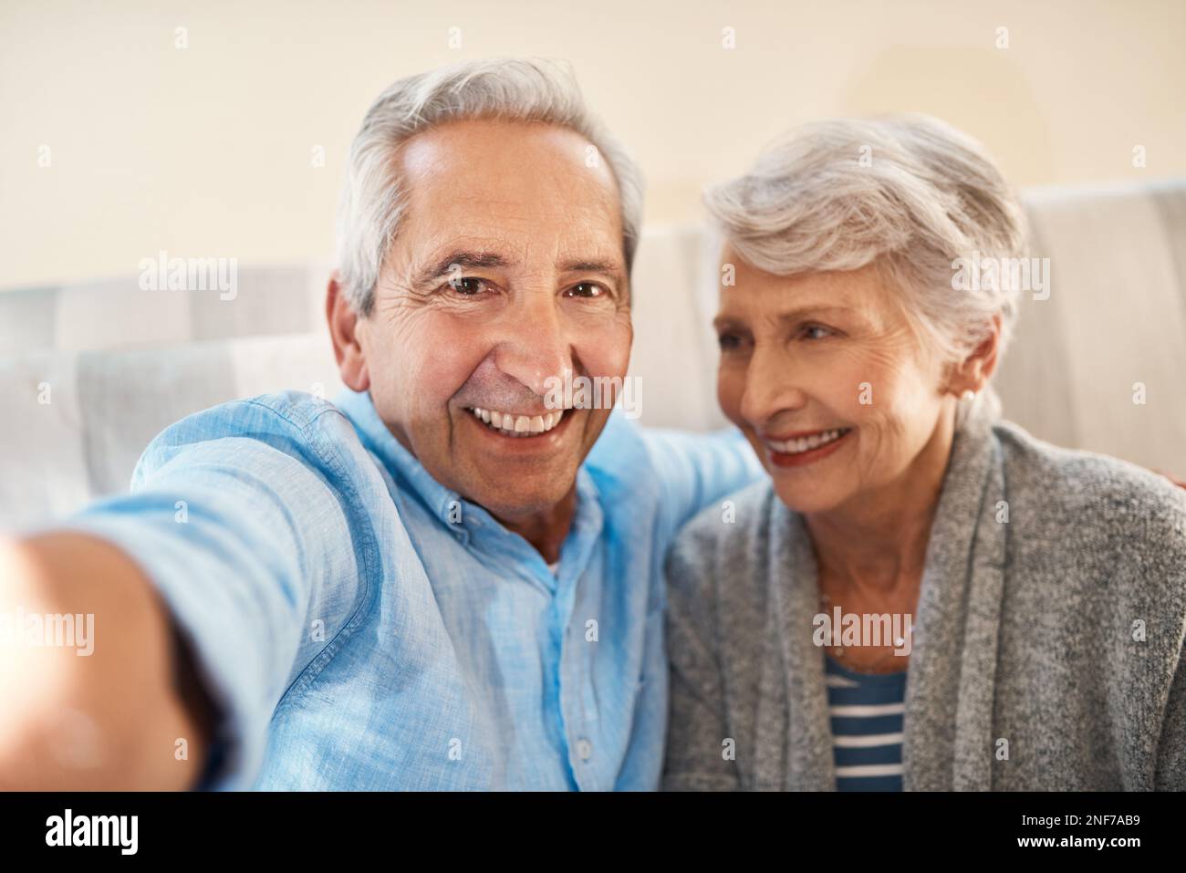 Getting our retirement off to a relaxing start. a senior couple taking selfie together on the sofa at home. Stock Photo