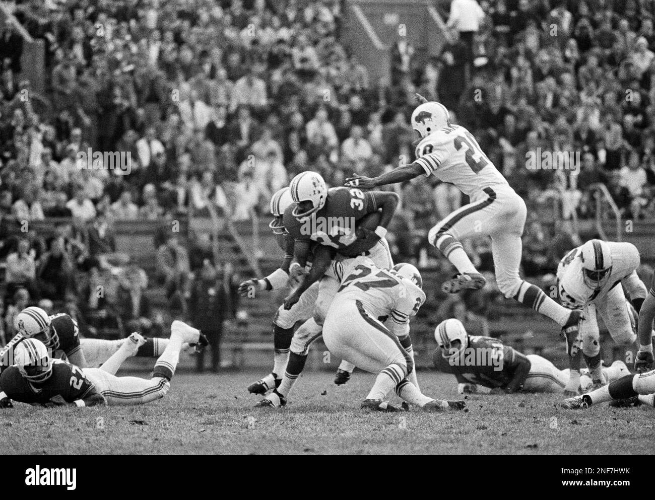 Buffalo Bills back Robert James (20) leaps through the air as teammate Tom  Pharr (27) and closes in on Boston Patriots back Odell Lawson (32) at  Harvard Stadium, Sunday, Nov. 1, 1970