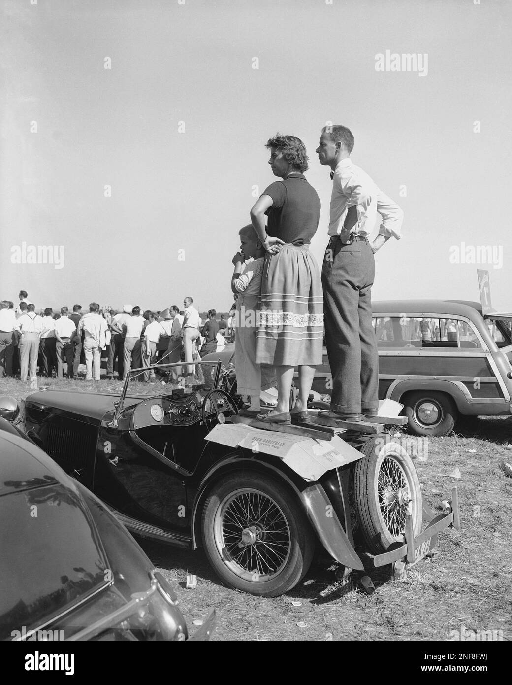 British MG sports cars were much in evidence on and off the track, at the  road races for foreign cars at the Linden Airport in New Jersey, Aug. 22,  1949. This family, image size:1040x1390