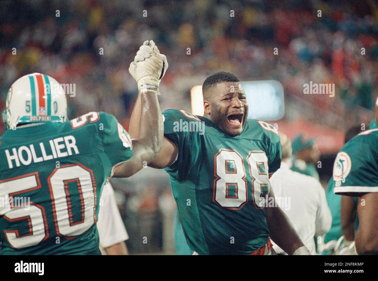 Miami Dolphins tight and Keith Jackson (88) celebrates the Dolphins 31-0  win over the San Diego Chargers in Miami, Jan. 10, 1993 as he passes  linebacker Dwight Hollier (50) after the game.