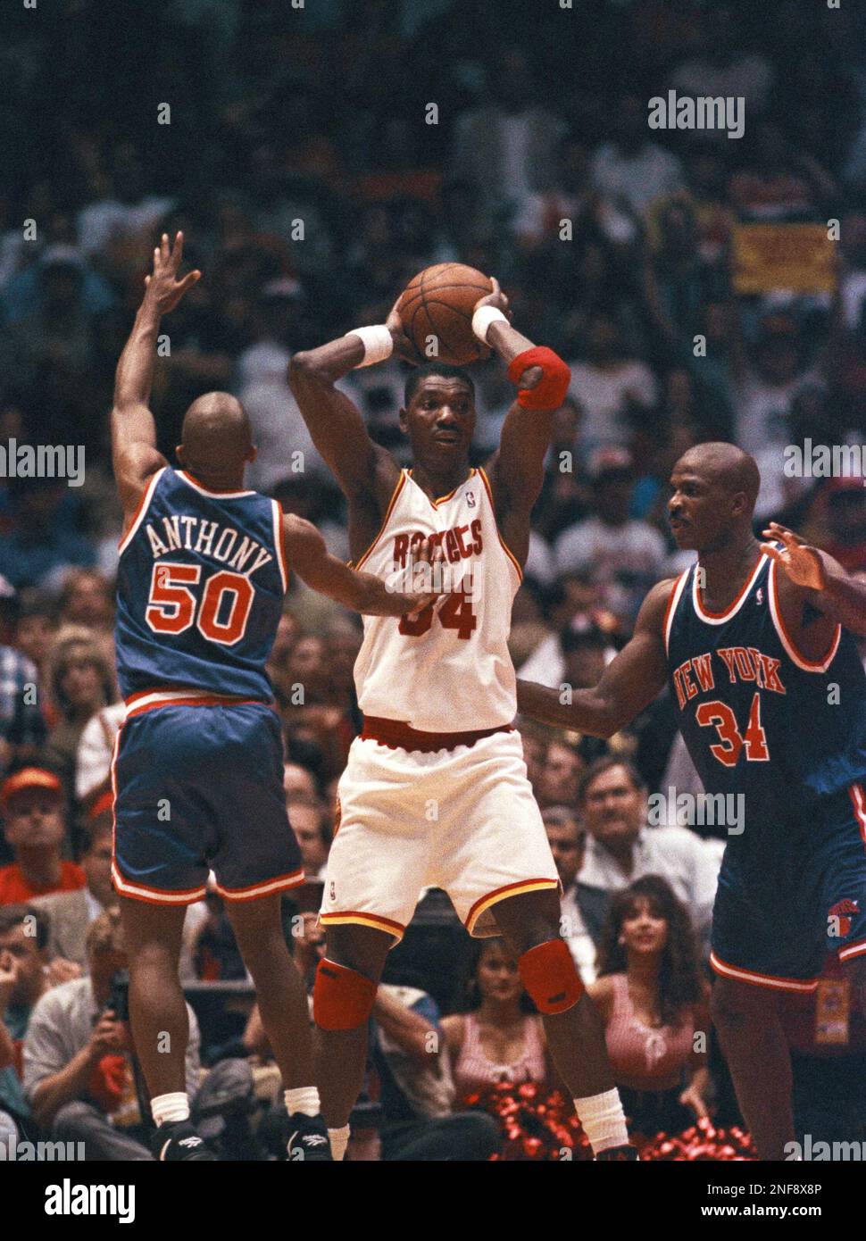 Houston Rockets’ Hakeem Olajuwon (34) looks to pass the ball between