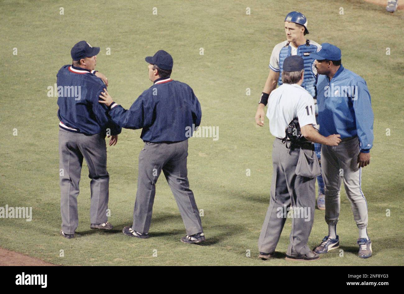 Home plate umpire Don Denkinger (11) keeps Toronto Blue Jays manager Cito  Gaston in place as Tim Tschida, middle, steers fellow umpire Jim Joyce away  following a bench clearing brawl with the
