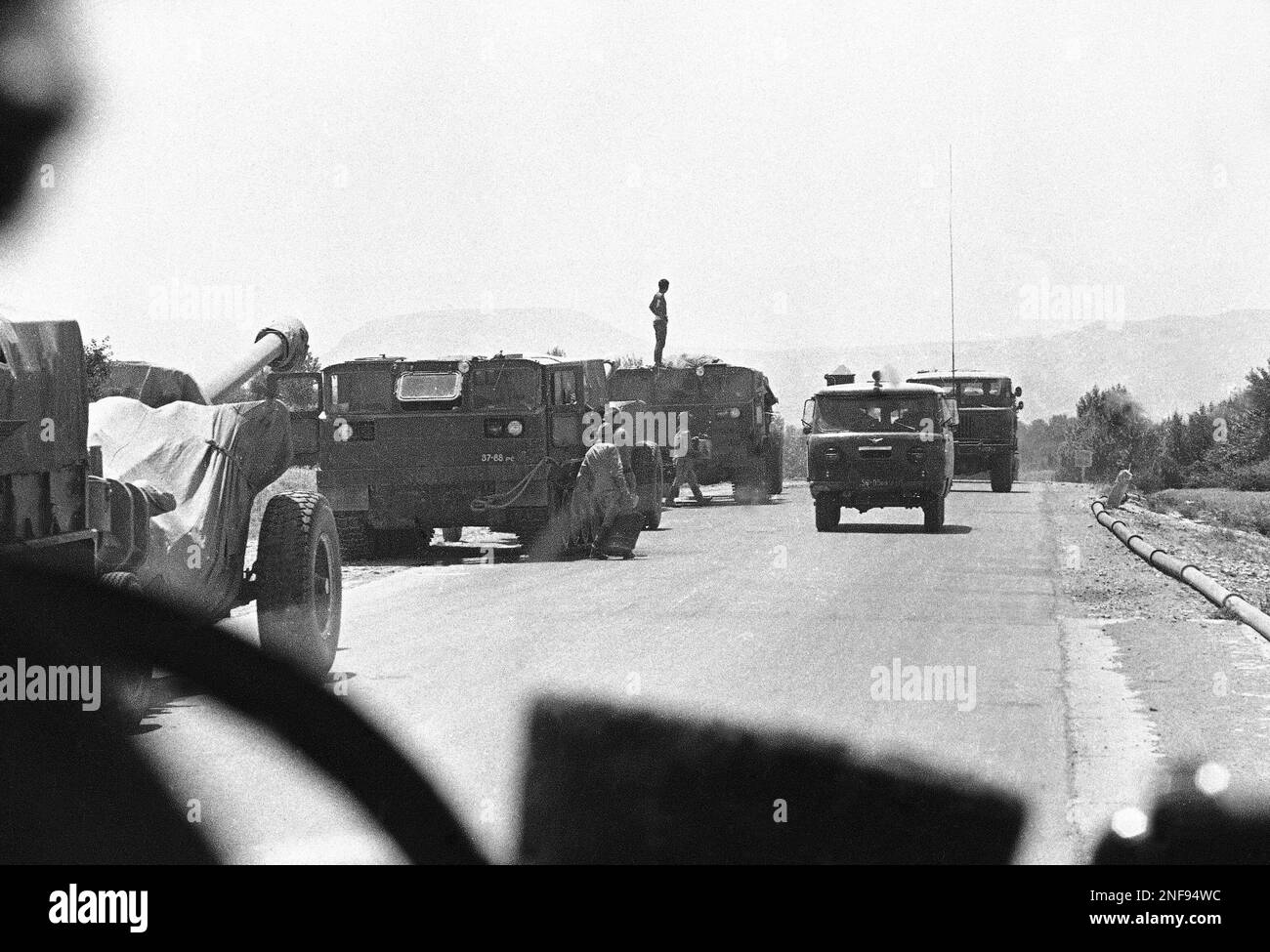 A Soviet Army convoy files past Soviet troops carriers and Howitzers ...