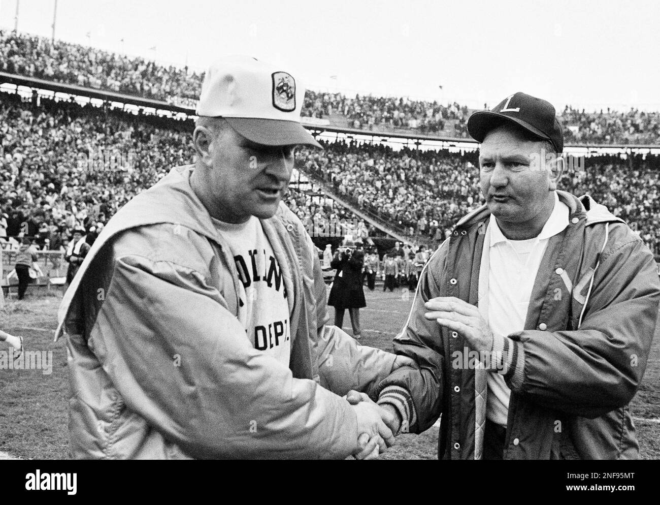 Lsu coach charlie mcclendon right pats the hand of wyoming coach
