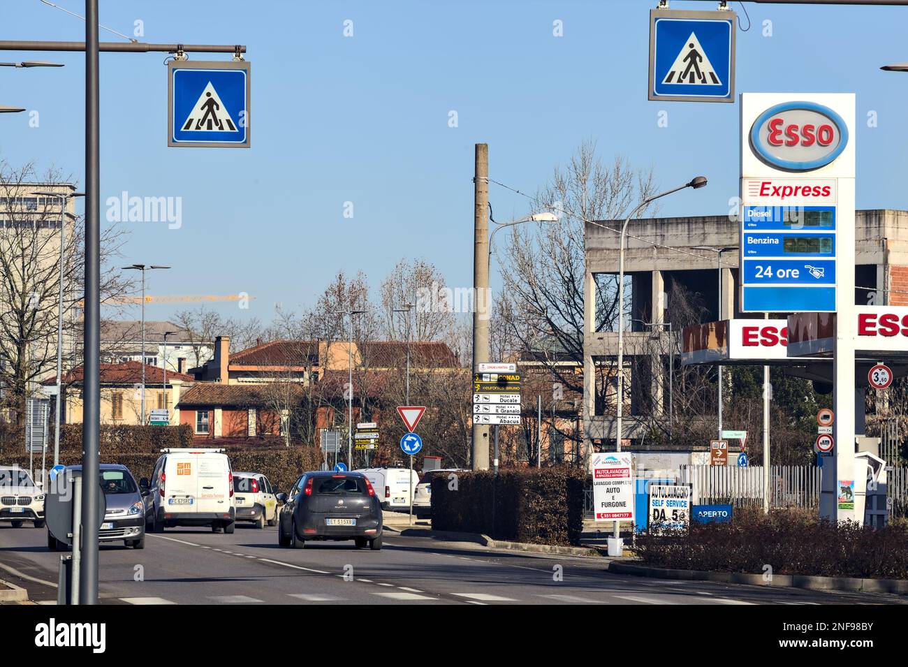 Country  road with gas stations and cars passing by on a sunny day Stock Photo