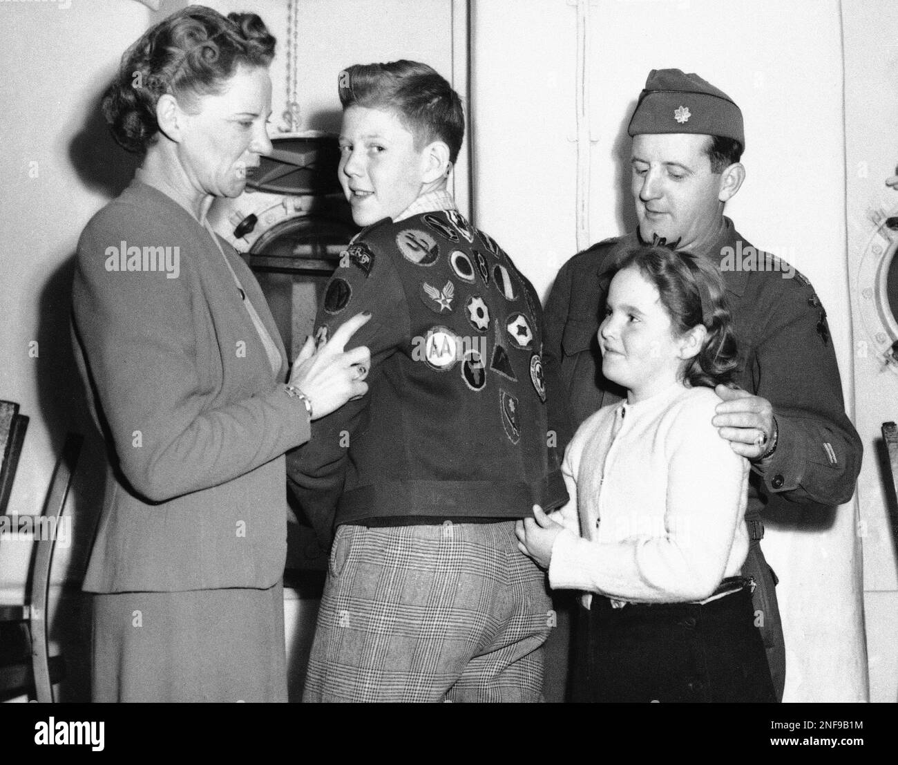 The Brumbaugh family admires the insignia decorated jacket worn by Norman Brumbaugh aboard the