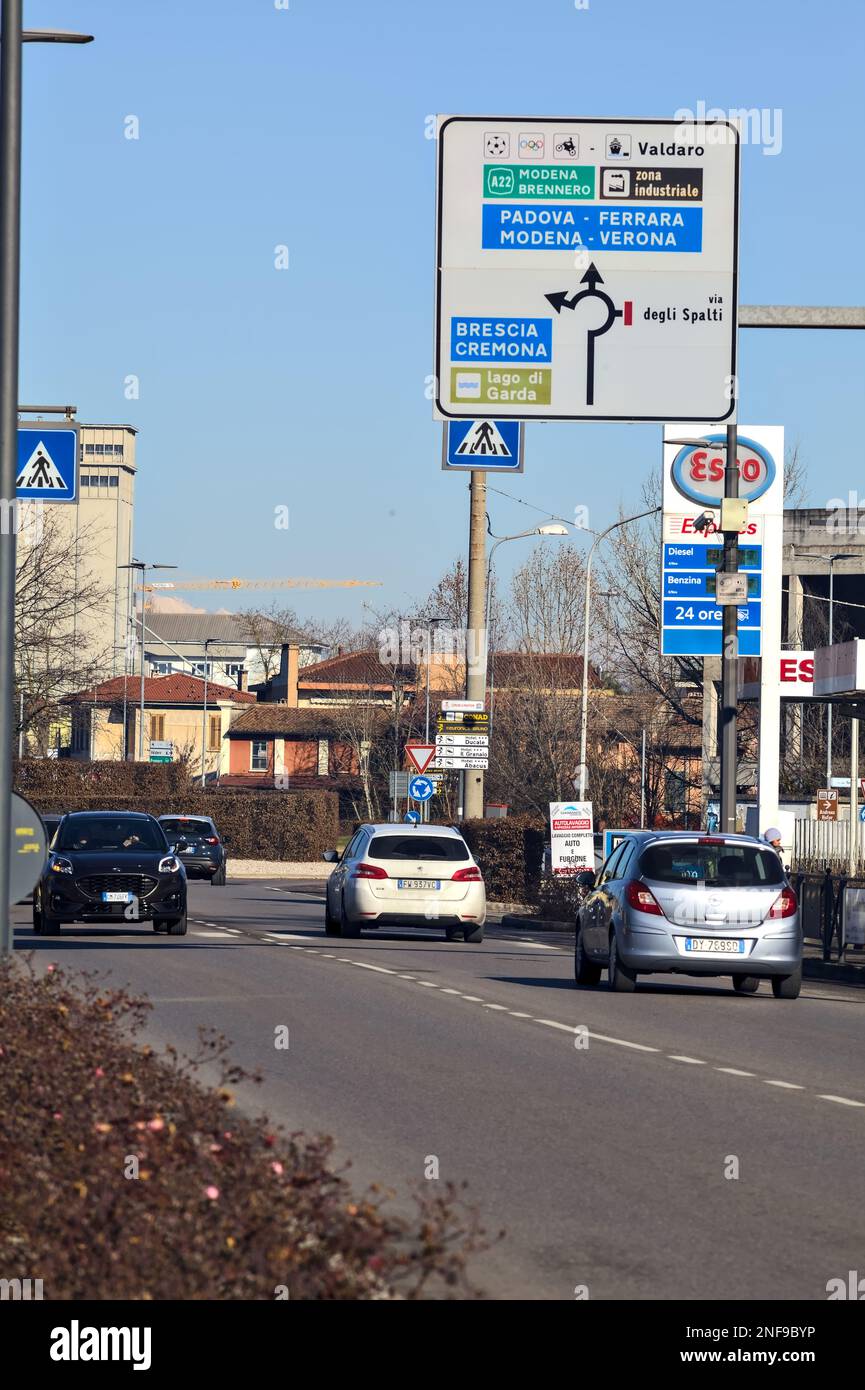 Country  road with gas stations and cars passing by on a sunny day Stock Photo