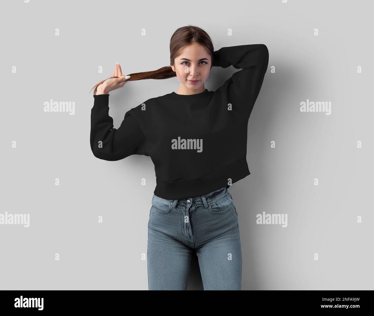 Mockup of a black sweatshirt on a posing girl, stylish clothes for design, print, pattern, advertising, front view. Template of cropped hoodie with ro Stock Photo