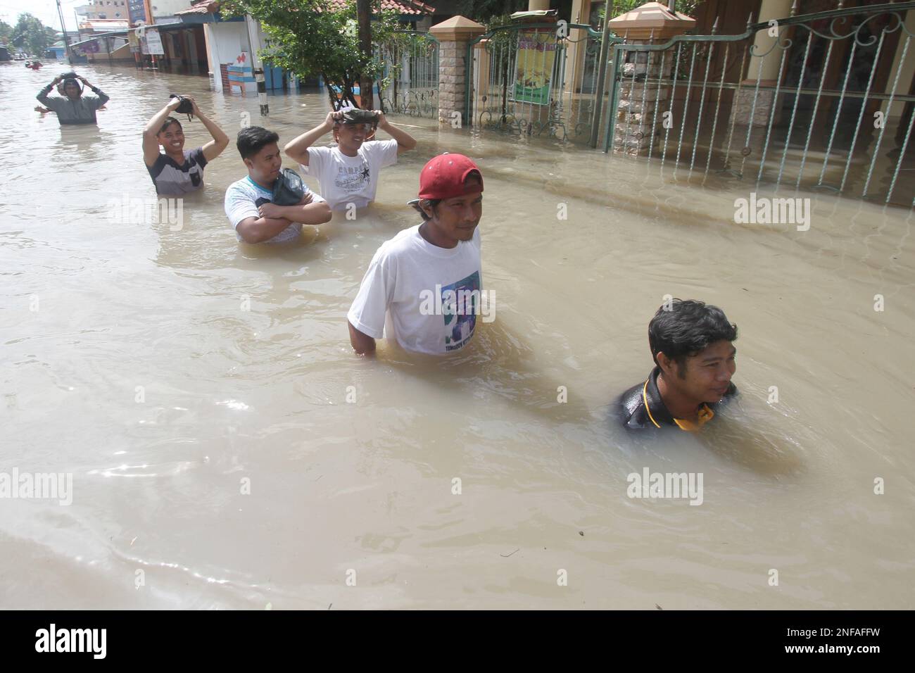 Surakarta, Indonesia. 17th Feb, 2023. People wade through flood water ...