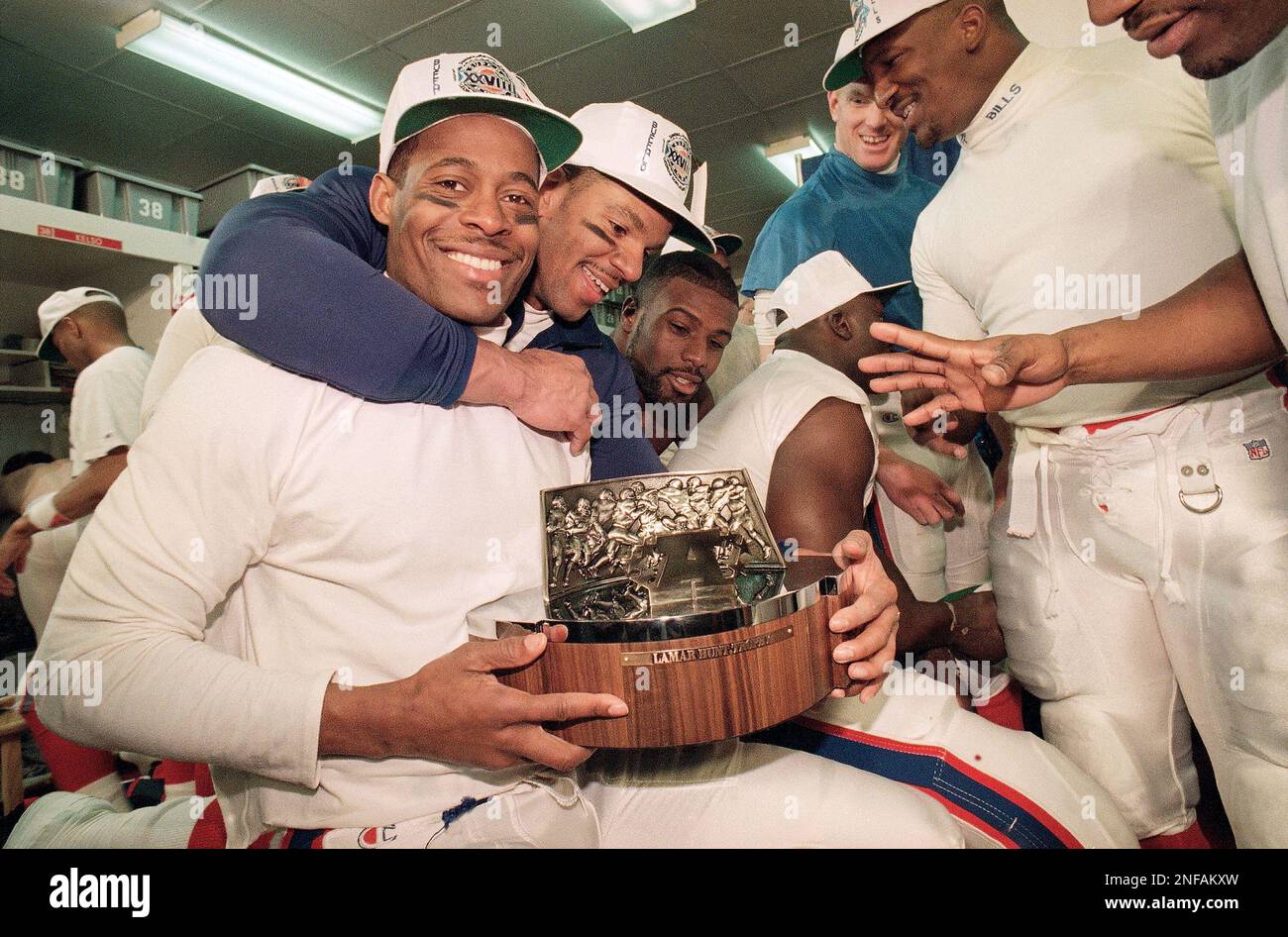 Buffalo Bills, from Left, Bill Brooks, Andre Reed, Mickey Washington, Bruce  Smith (looking away), Pete Metzelaars (standing), Carwell Gardner, and Nate  Odomes (reaching) celebrate in their Locker room with the Lamar Hunt