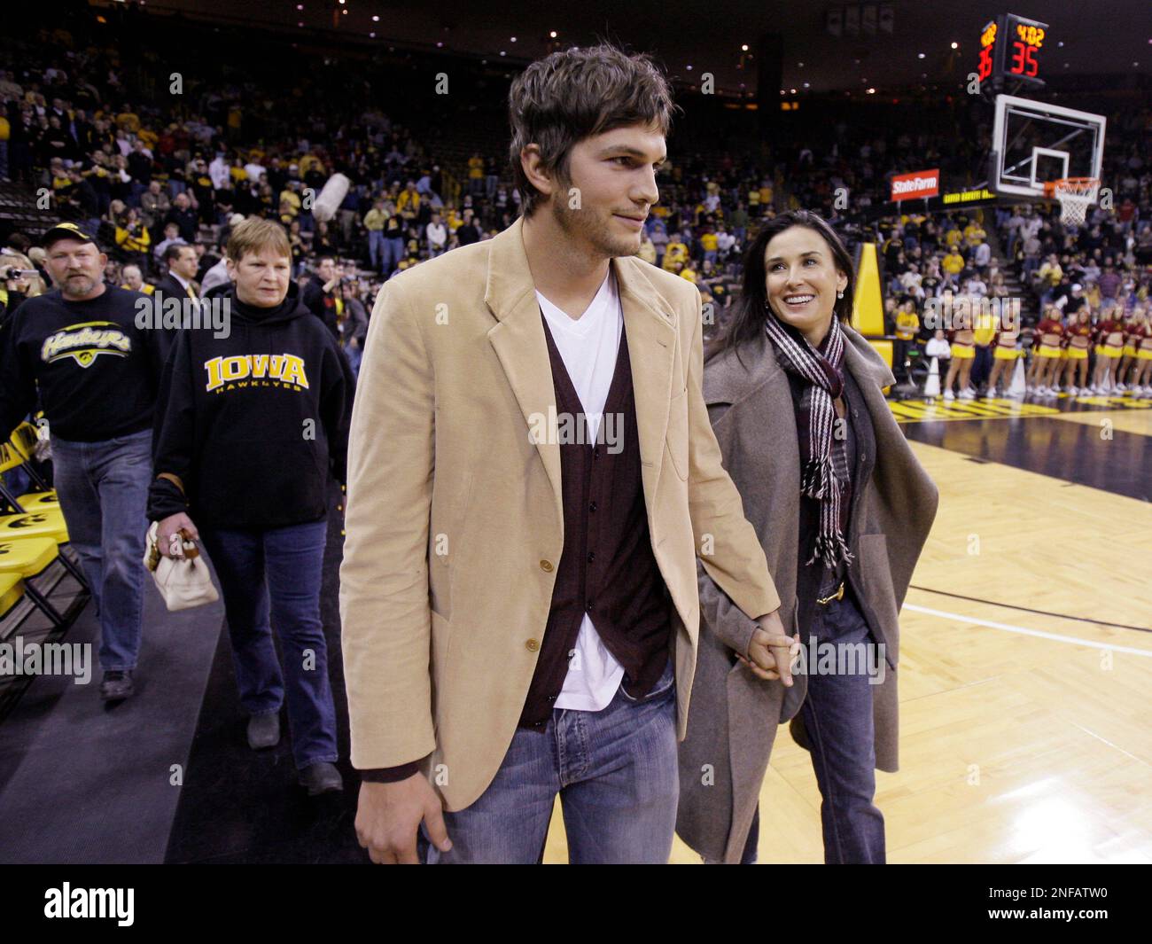 Actor Ashton Kutcher and his wife Demi Moore walk on the court before