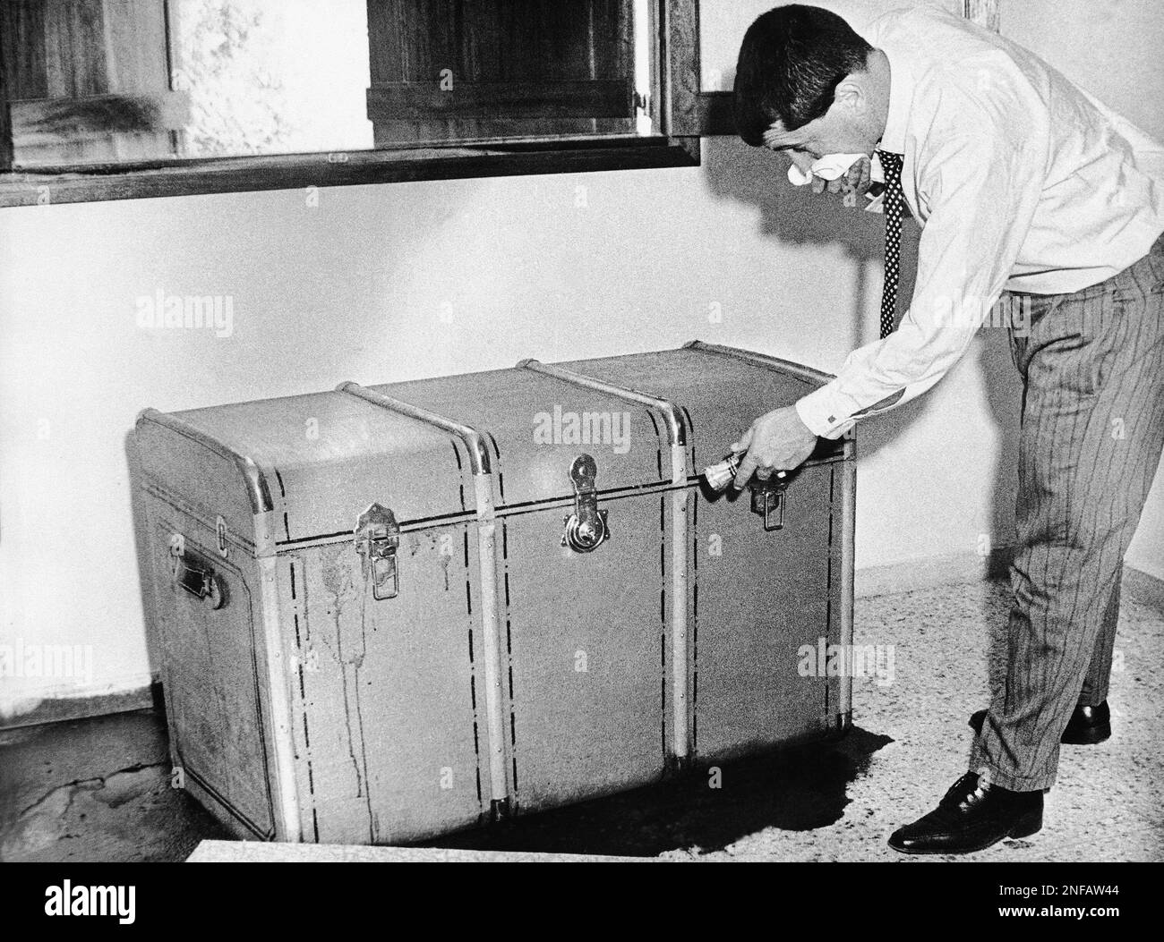 The body of the elder Herberts Cukurs, accused of killing 30,000 Jews in Latvia in World War II, was found in a trunk in Montevideo, Uruguay, March 6, 1965. Man opening trunk is unidentified. (AP Photo) Stock Photo