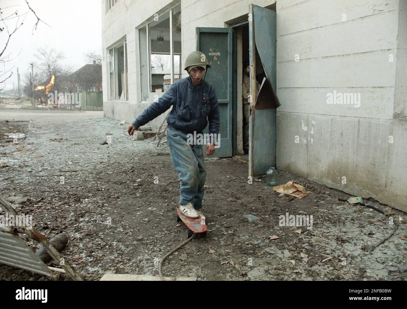 A boy wearing a Russian army helmet plays on a skateboard despite ...
