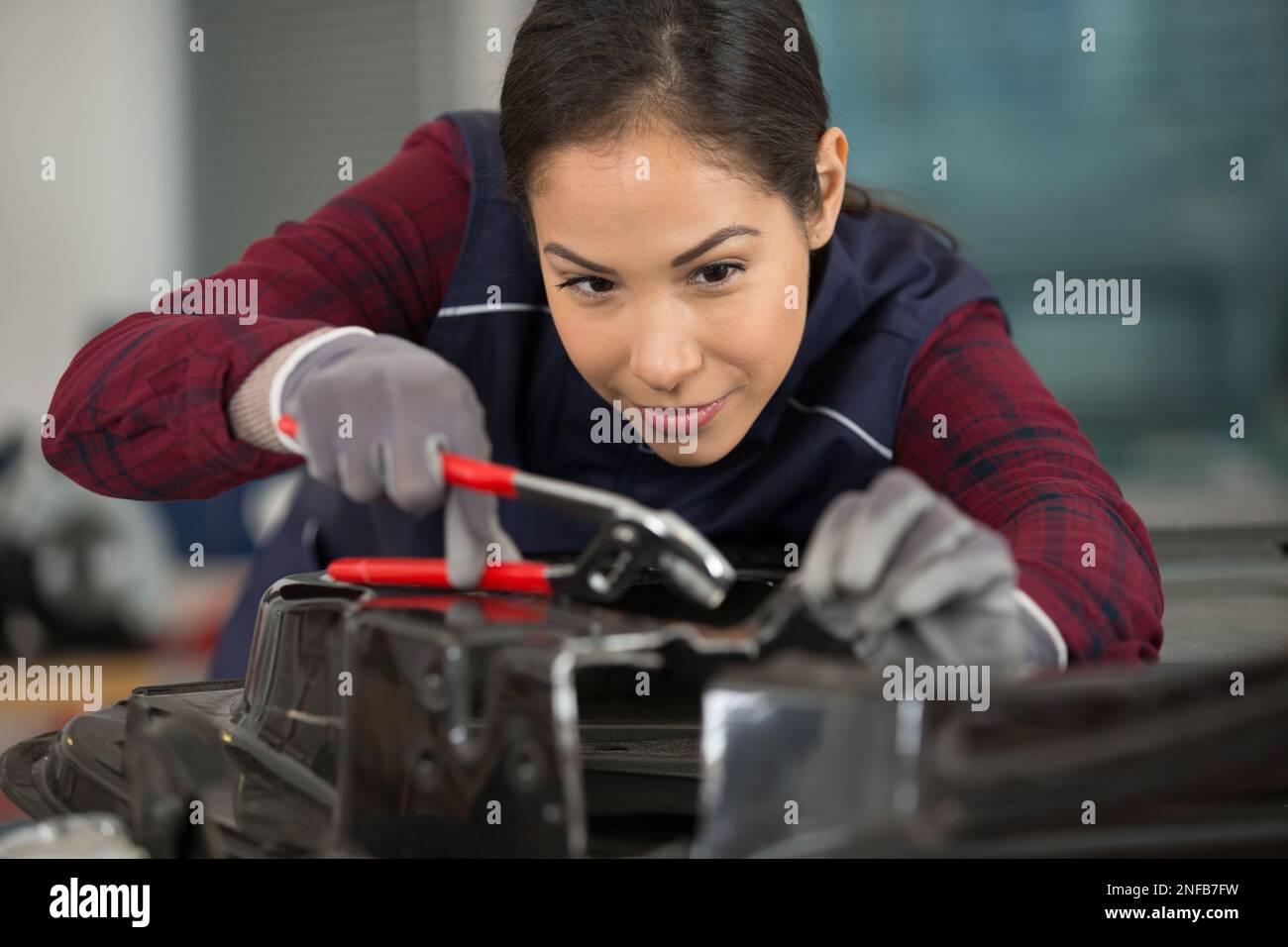 female mechanic using pliers Stock Photo