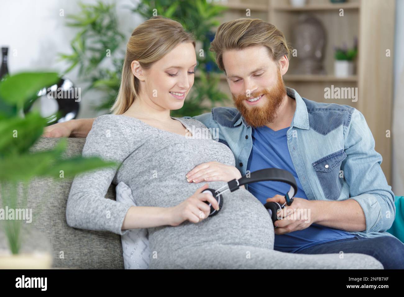 pregnant couple making belly listen music Stock Photo - Alamy