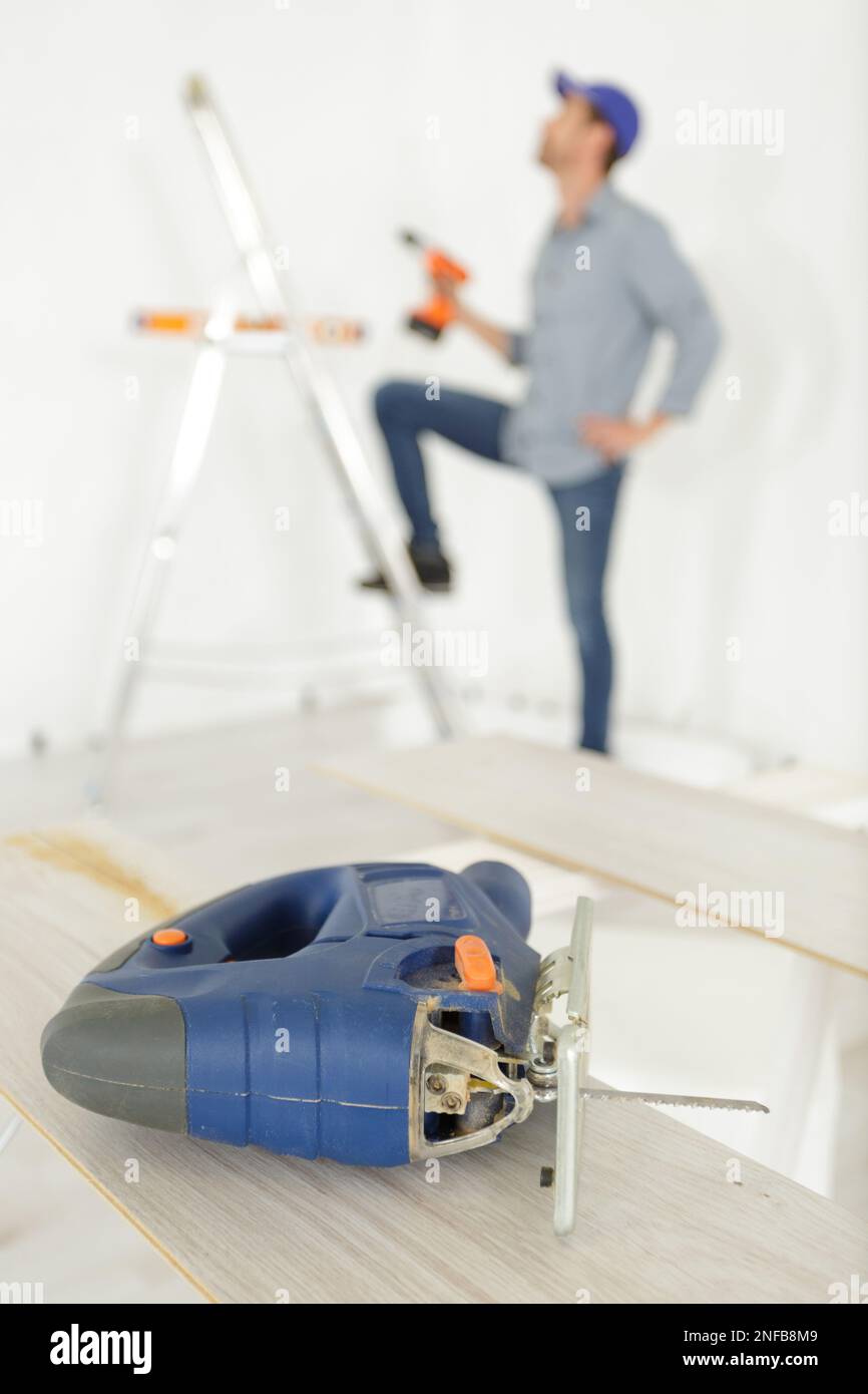 a man with a reciprocating saw Stock Photo