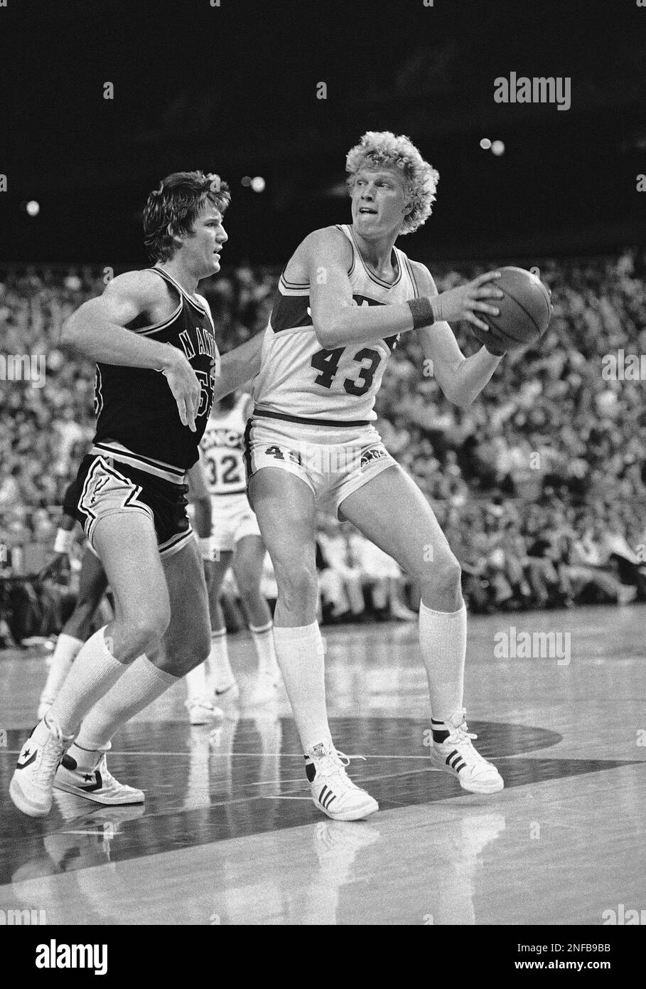 Seattle Supersonics Jack Sikma 43 turns towards the basket to shoot as Mark Olberding 43 of the San Antonio Spurs applies the defense at Seattle May 6 1982. San Antonio beat Seattle