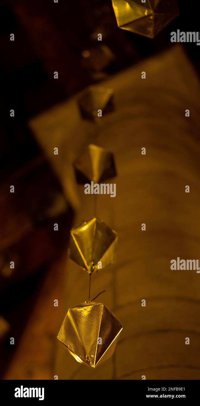 Low angle detail of a golden diamond hanging from the wooden ceiling of ...