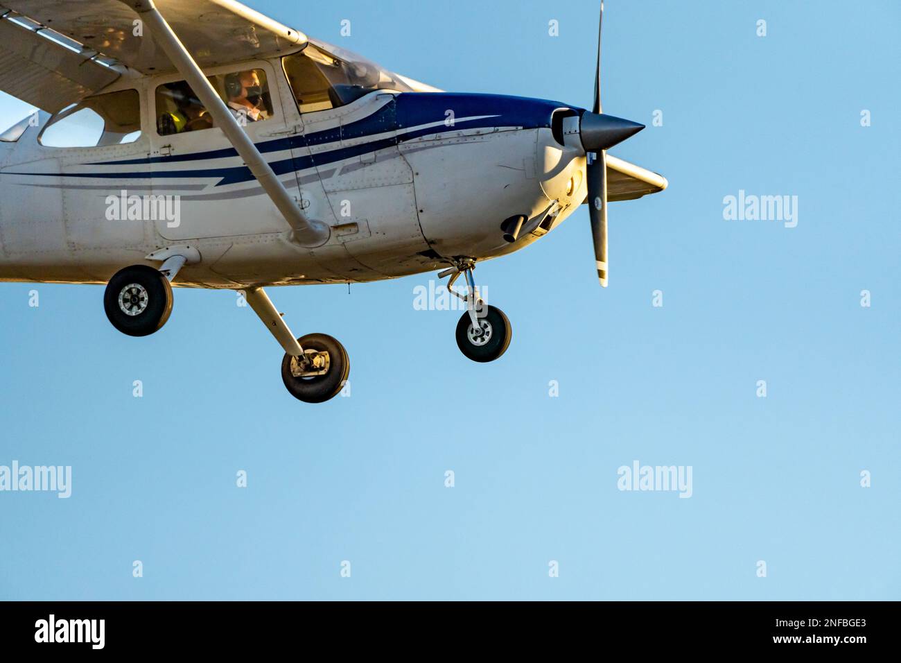 Small propeller plane landing or taking off on the runway at Sabadell airport with a totally clear blue sky in the evening under a twilight sun. Stock Photo