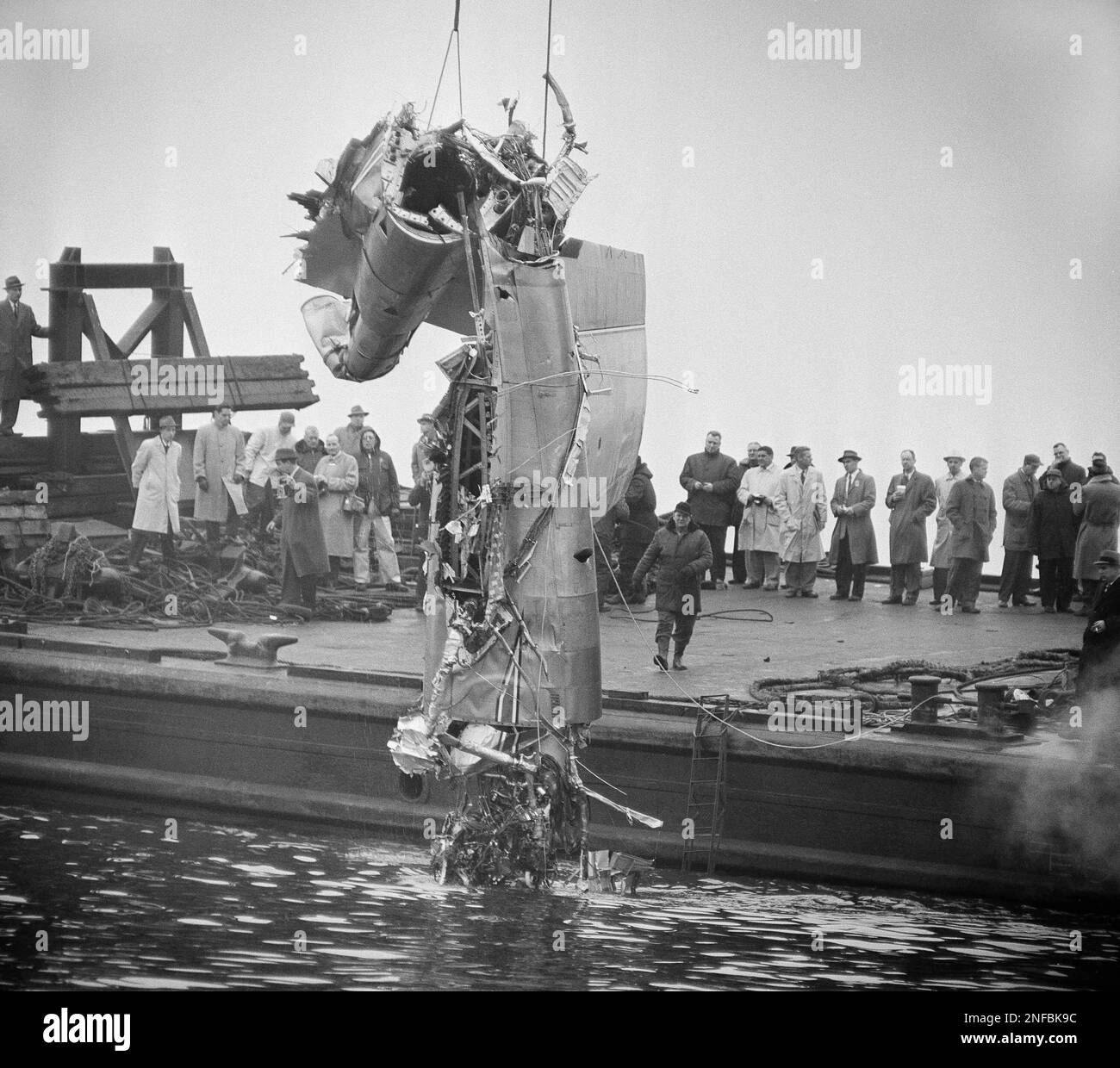 Derrick hoists a portion of wing and engine of wrecked American