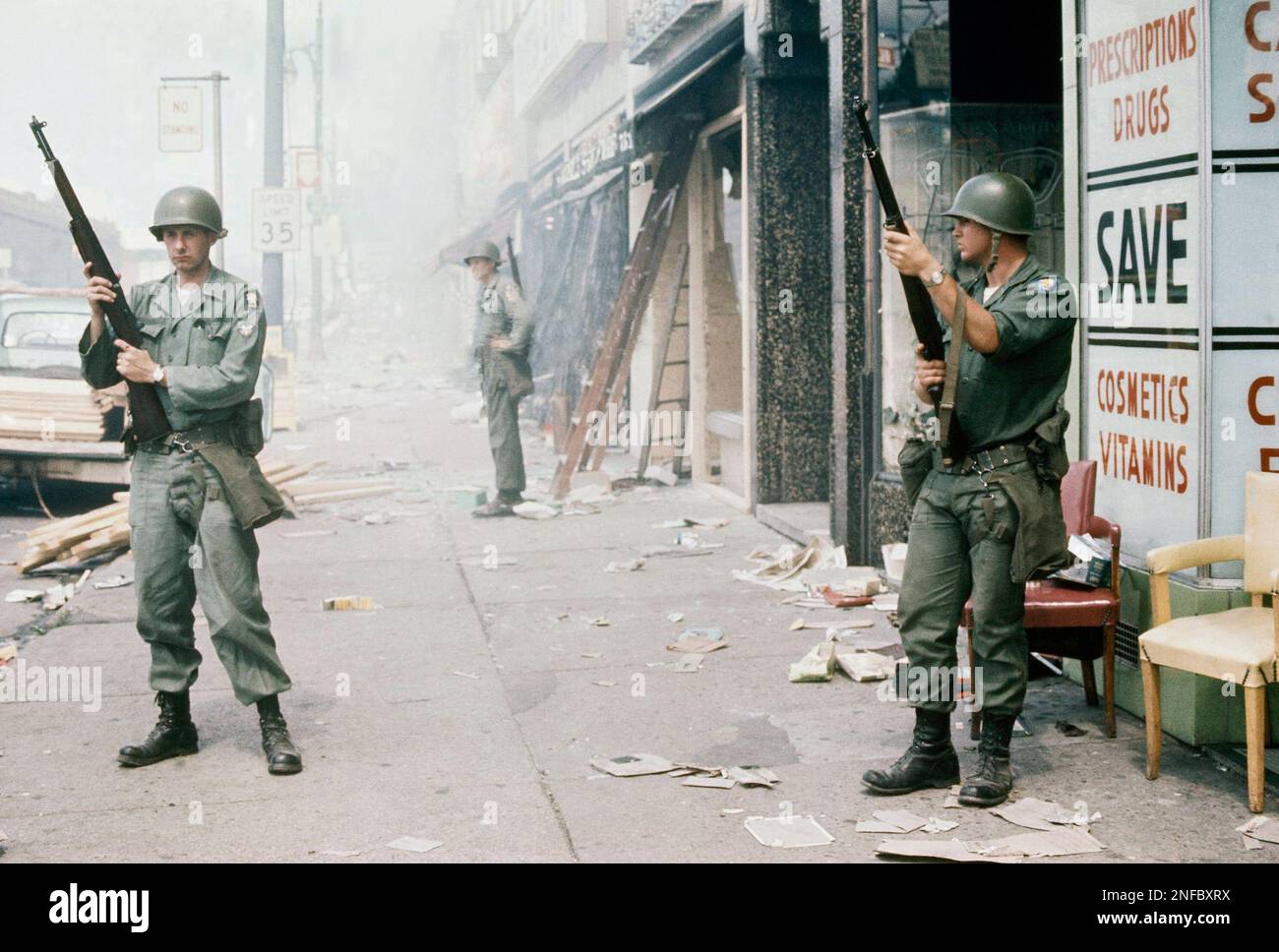 National Guardsmen stand guard on riot torn street in Detroit, Mich ...