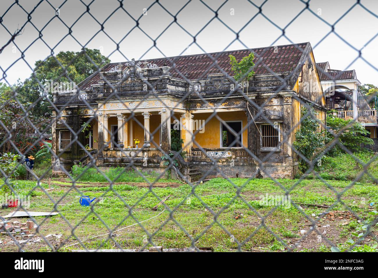 A run down building behind a chain link fence in Hoi An, Vietnam Stock  Photo - Alamy