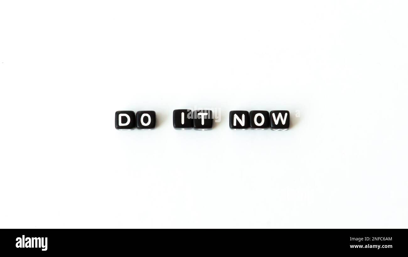 Do it now motivation quote in black letter beads on white background. Top view. Mock up copy space Stock Photo