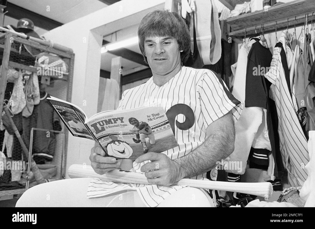 Philadelphia Phillies first baseman Pete Rose looks over a children's book  by teammate Tug McGraw as he sits in the club's locker room at Jack Russell  Stadium in Clearwater, Fla., March 10